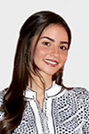 Portrait of Nicoletta Pearce against a white background, wearing a black and white shirt