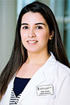 Portrait of Susan Wahab, indoors and wearing a white coat and black shirt